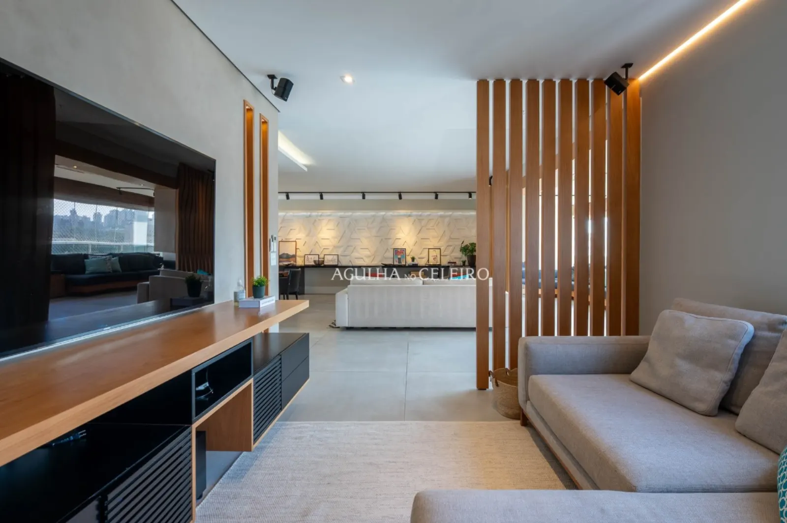 Sala de TV / home theater independente com marcenaria em madeira.