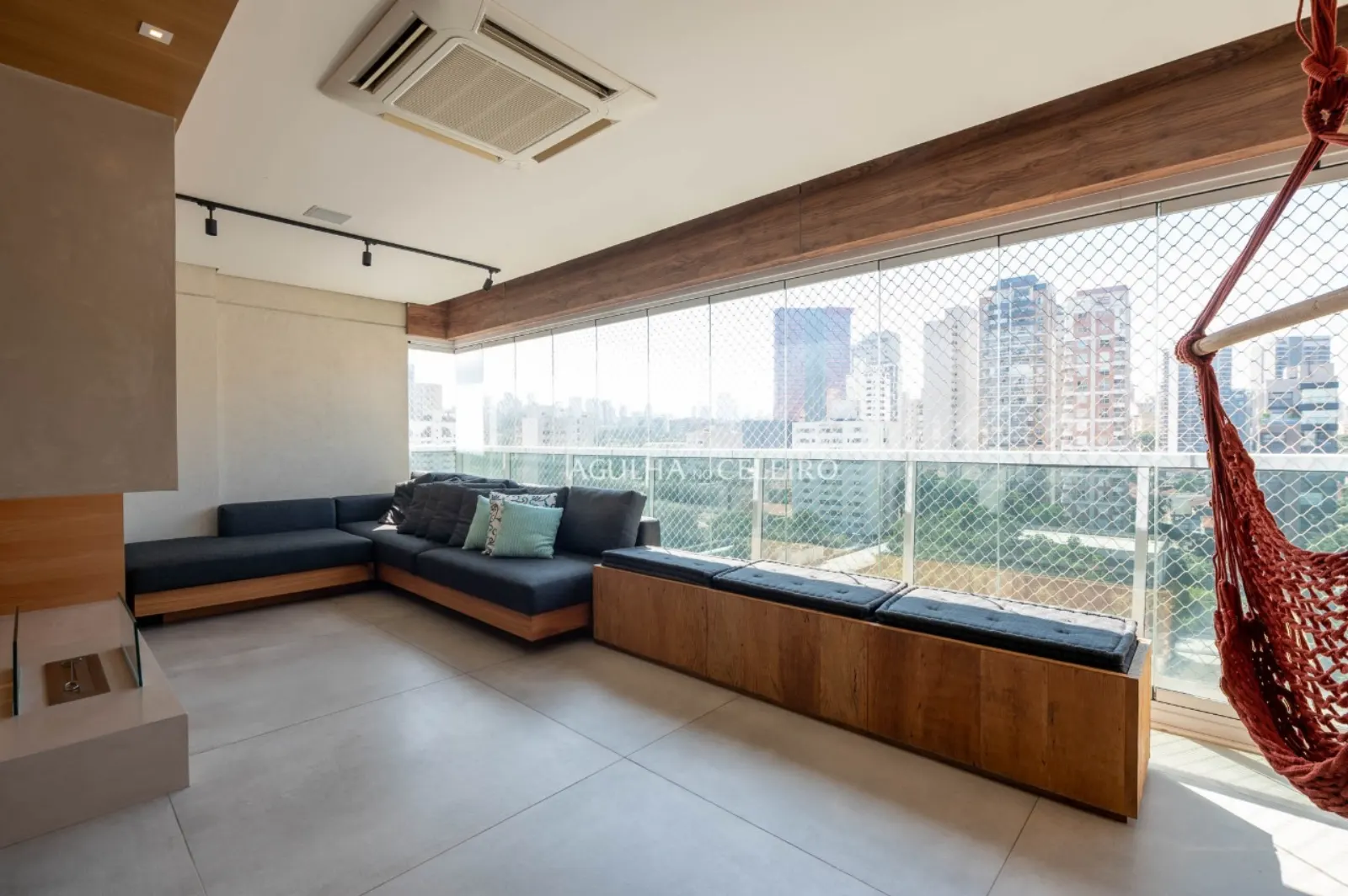 Varanda social com vista panorâmica para Pinheiros e área de descanso.